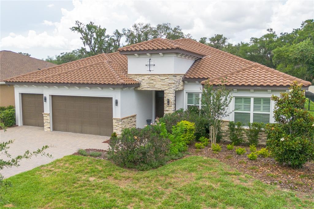 A single-story house with a tile roof, stone accents, and a three-car garage — 113 BROOKOVER LANE, BRANDON, FL