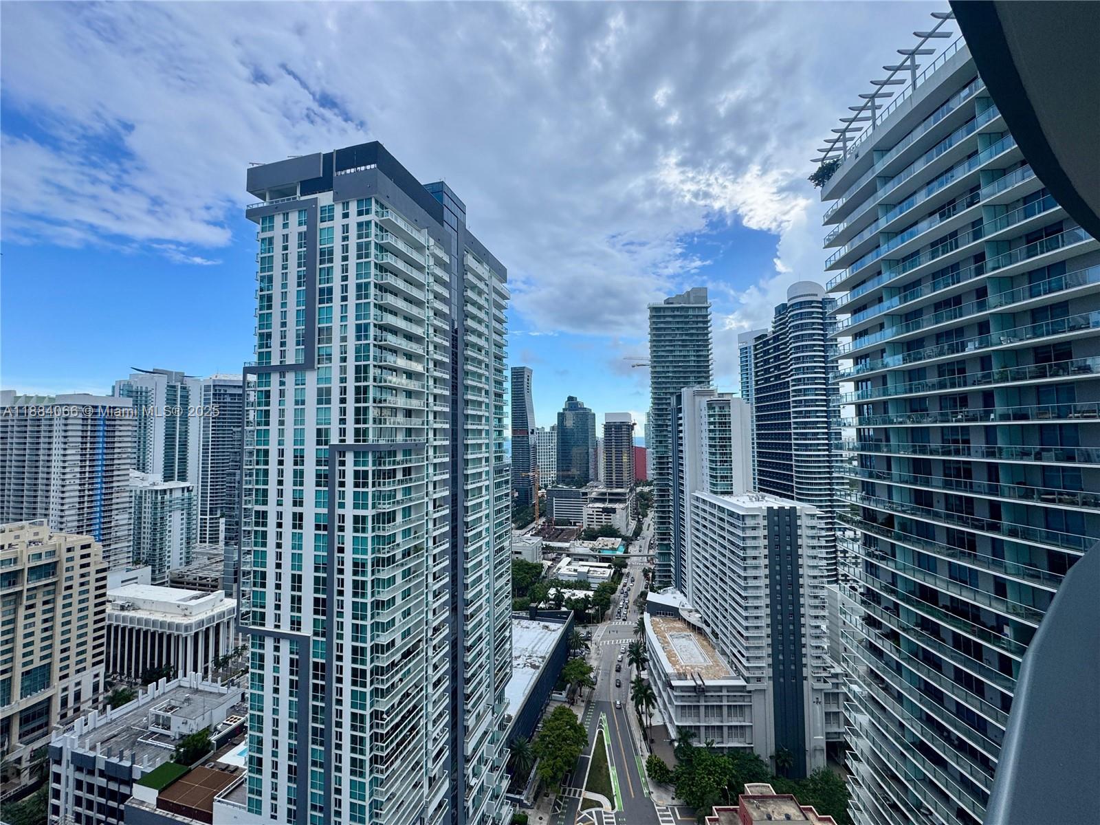 An elevated view of a dense city skyline featuring multiple modern glass high-rise apartment buildings — 1000 Brickell Plz # 3302, Miami FL 33131, MIAMI, FL