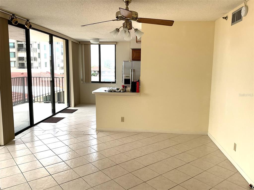 A living area with tile floors, a ceiling fan, and a sliding glass door balcony entrance — 6322 PALMA DEL MAR BOULEVARD S UNIT G402, ST PETERSBURG, FL