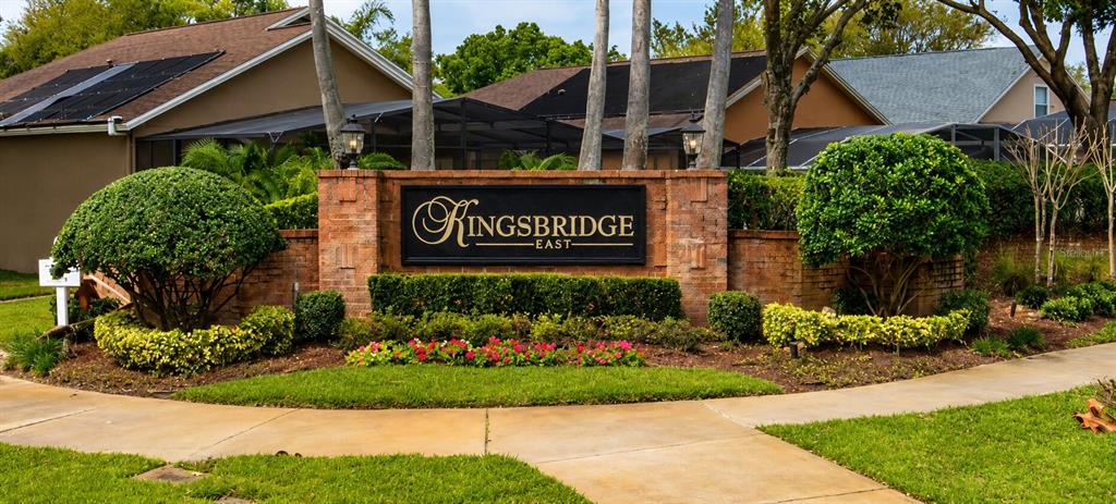A brick monument sign for Kingsbridge East stands in front of residential homes with solar panels — 649 BUCKINGHAM DRIVE, OVIEDO, FL