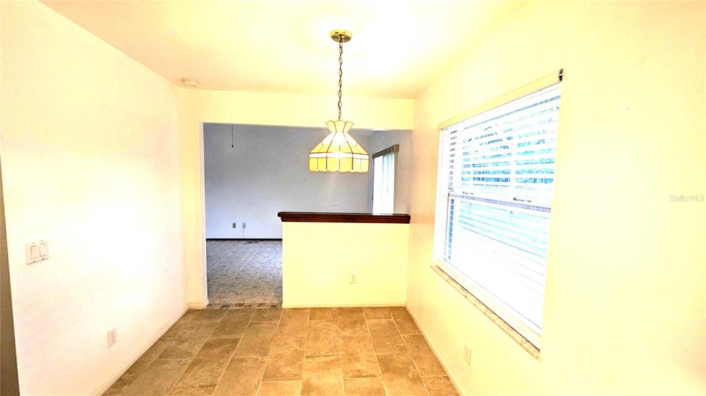 A dining area features tile flooring, a hanging pendant light, and a window with blinds — 8067 SWEETGUM LOOP, ORLANDO, FL