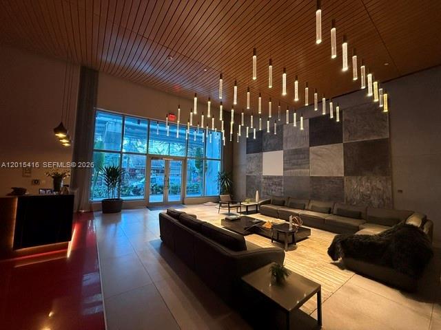 A modern lobby features a high wood-slat ceiling, numerous pendant lights, and large sectional sofas — 1100 S Miami Ave # 801, Miami FL 33130, MIAMI, FL