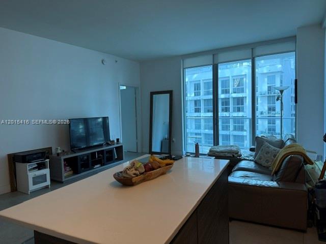 A living room features a kitchen island, a television on a stand, and a sofa — 1100 S Miami Ave # 801, Miami FL 33130, MIAMI, FL