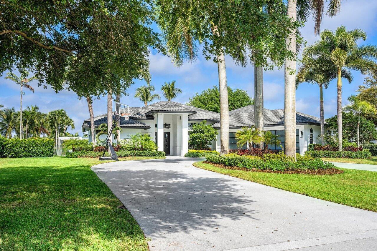A single-story white house with a gray tile roof and a basketball hoop in front — 8331 Sawpine Road, Delray Beach FL 33446, DELRAY BEACH, FL