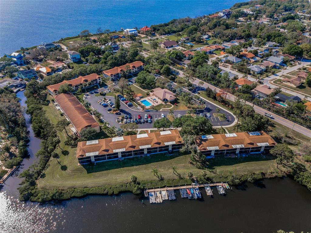 A two-story apartment building exterior features a central staircase leading to an upper balcony — 1686 SEASCAPE CIRCLE, TARPON SPRINGS, FL