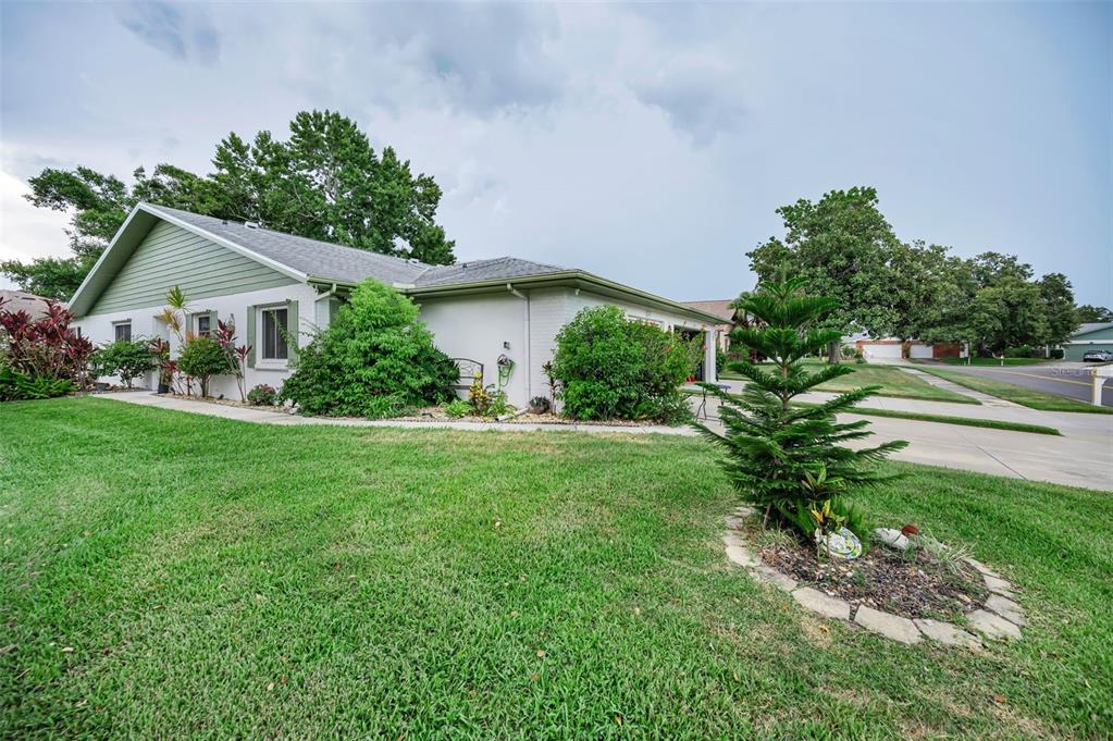 A single-story house with a green gable roof and white exterior sits on a lawn — 3215 MCMATH DRIVE, PALM HARBOR, FL
