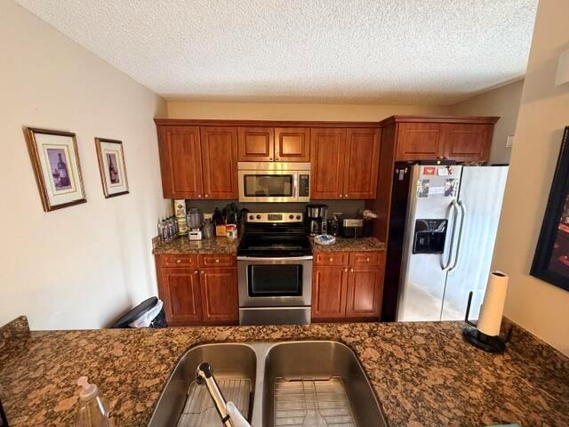 A kitchen features wood cabinets, stainless steel appliances, and a granite countertop with a sink — 3711 37th Way, West Palm Beach FL 33407, WEST PALM BEACH, FL