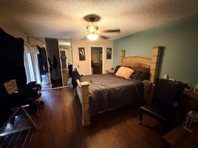 A bedroom features a wooden bed frame, dark bedding, a ceiling fan, and hardwood flooring — 3711 37th Way, West Palm Beach FL 33407, WEST PALM BEACH, FL