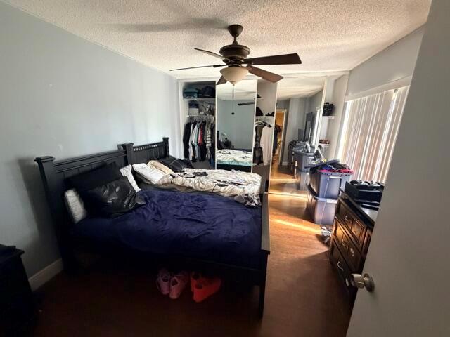 A bedroom features a black bed frame, a ceiling fan, and a mirrored closet — 3711 37th Way, West Palm Beach FL 33407, WEST PALM BEACH, FL