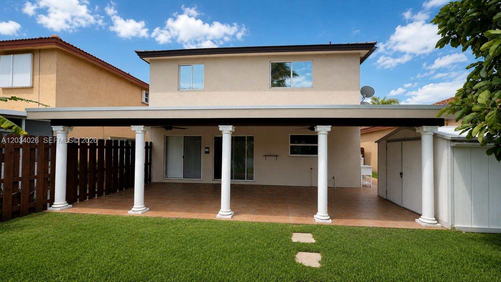 A two-story house features a covered patio with white columns and a tiled floor — 12211 SW 137th Ter, Miami FL 33186, MIAMI, FL