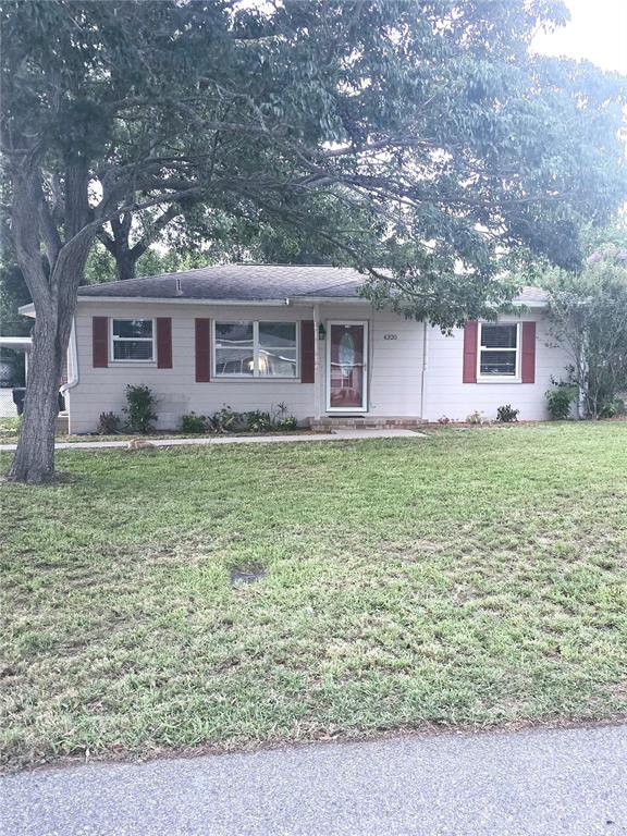 A single-story house with light siding, red shutters, and a large tree in the yard — 4320 HEDGE DRIVE N, LAKELAND, FL