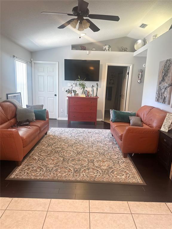 A living room features two leather sofas, a patterned area rug, and a wall-mounted television — 2527 10TH AVENUE S, ST PETERSBURG, FL