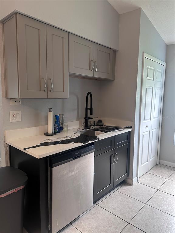 A small kitchen features gray upper cabinets, black lower cabinets, and a white countertop — 2527 10TH AVENUE S, ST PETERSBURG, FL