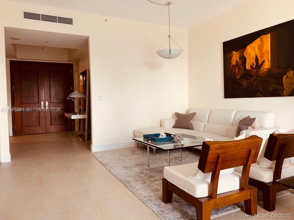 A living room features a white sectional sofa, wooden chairs, and a large abstract painting — 1425 Brickell Ave # 43D, Miami FL 33131, MIAMI, FL