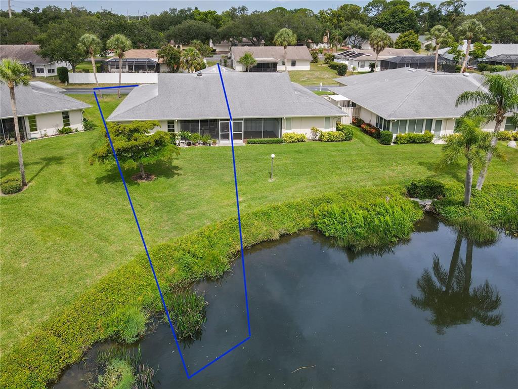 An aerial view shows a single-story house with a screened patio overlooking a pond — 4136 BOWLING GREEN CIRCLE UNIT 23, SARASOTA, FL