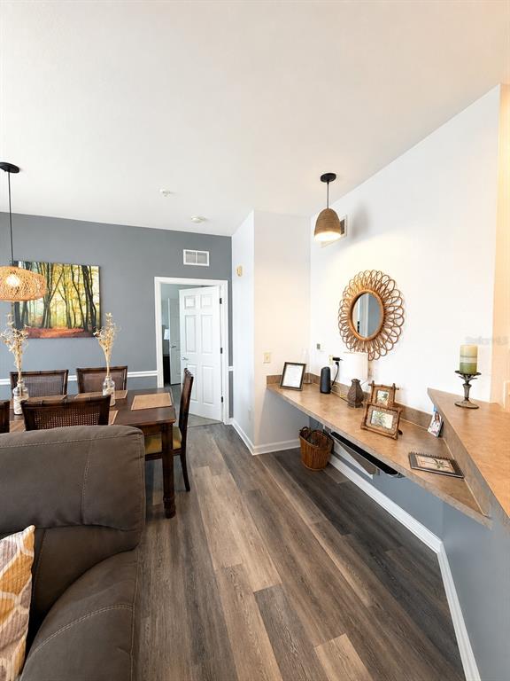 A dining area with wood flooring features a built-in desk and a gray accent wall — 313 TERRACE RIDGE CIRCLE UNIT 313, DAVENPORT, FL