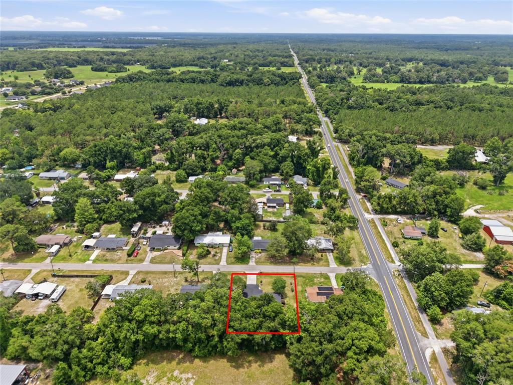 An aerial view shows a single-story house surrounded by trees and a red boundary line — 18145 NW 250TH TERRACE, HIGH SPRINGS, FL
