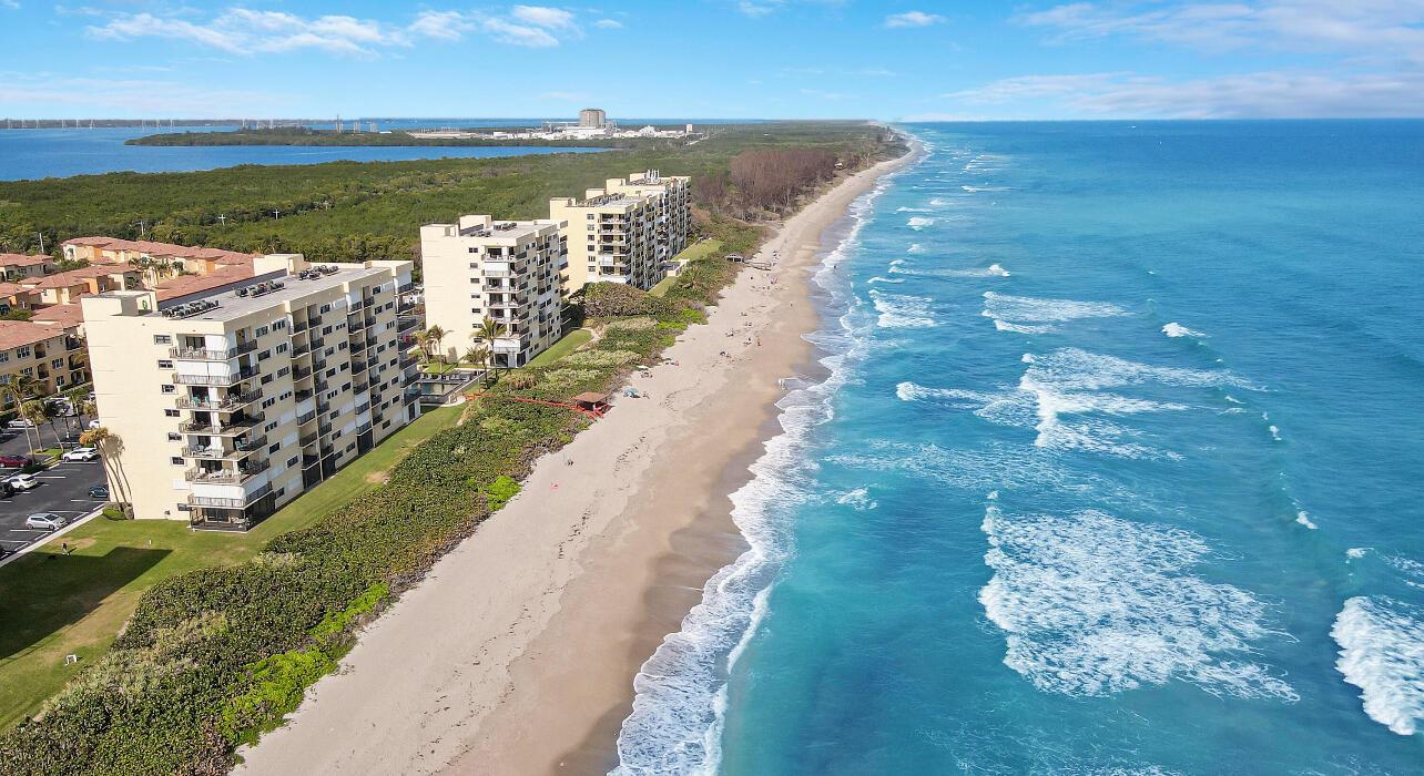 An aerial view of beachfront condominiums situated along a sandy coastline next to the ocean — 7410 S Ocean Drive # 505, Jensen Beach FL 34957, JENSEN BEACH, FL
