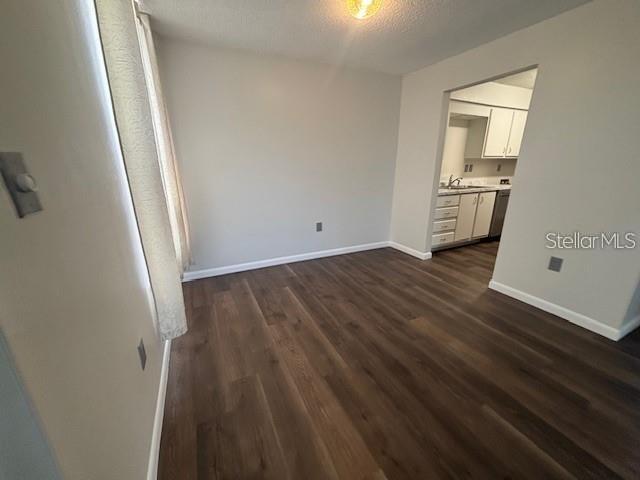 A dining area with wood-look flooring leads into a kitchen with white cabinets — 528 ORANGE DRIVE UNIT 26, ALTAMONTE SPRINGS, FL