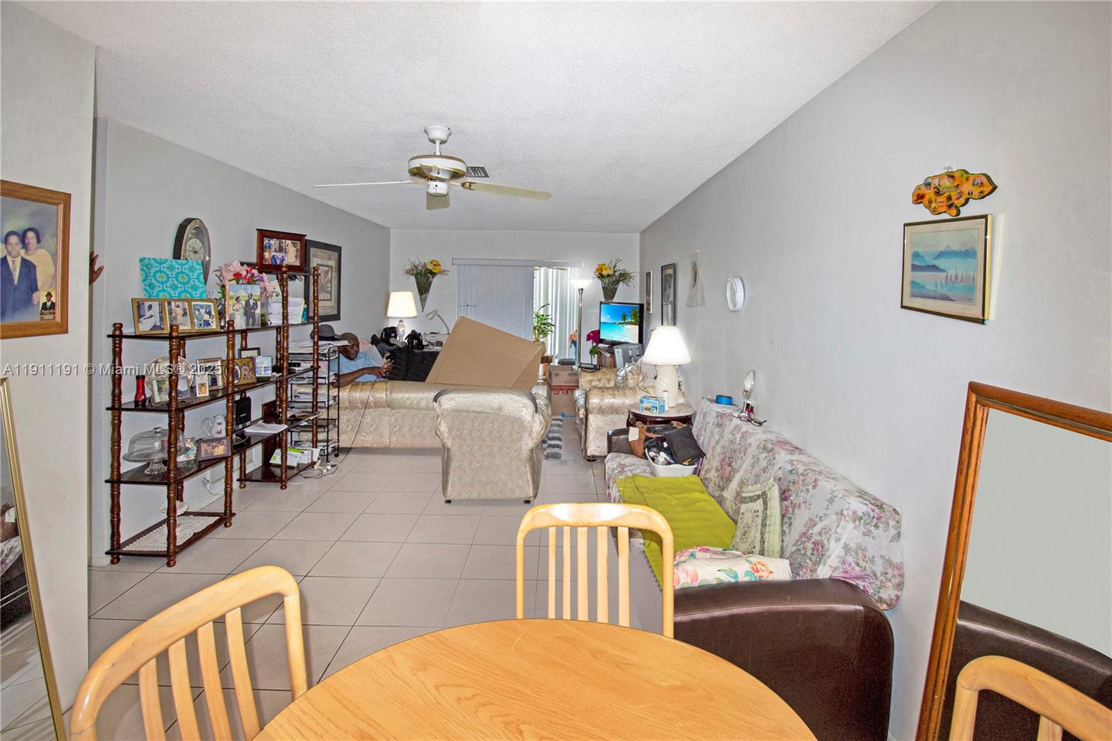 A living room features tile flooring, a ceiling fan, and a floral-patterned sofa — 2112 NE 1st Way # 203, Boynton Beach FL 33435, BOYNTON BEACH, FL