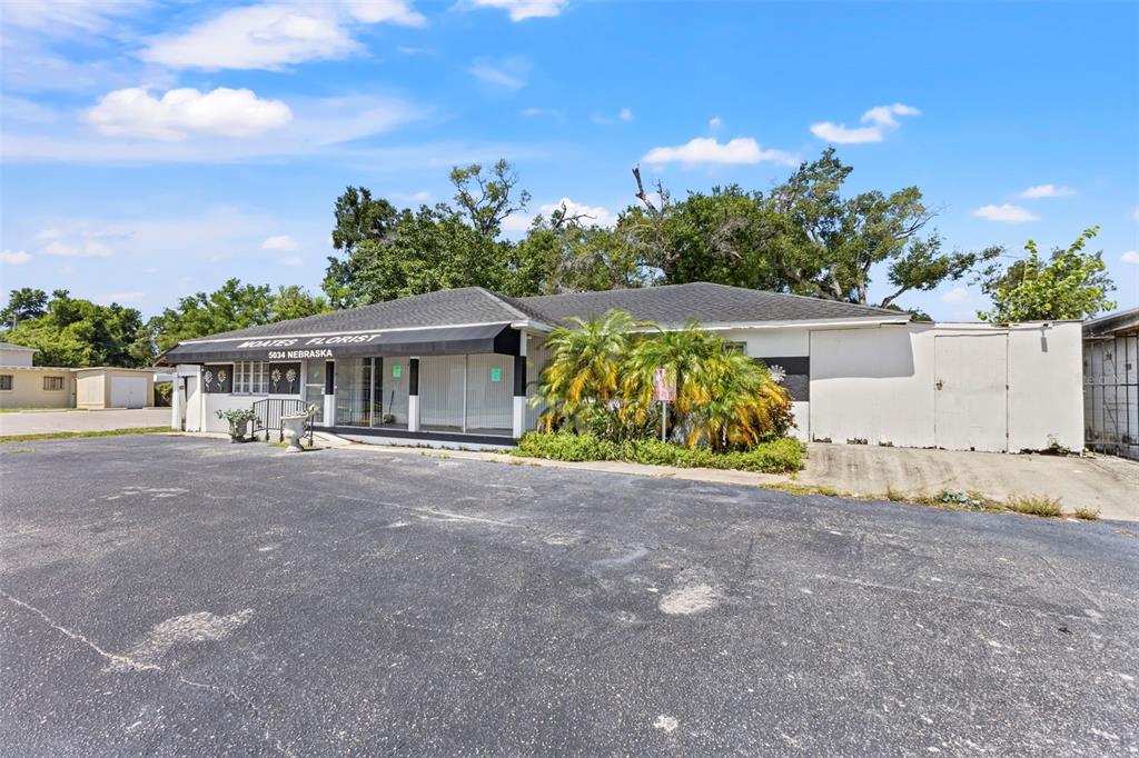 A single-story commercial building with a black awning and a large asphalt parking lot — 5034 N NEBRASKA AVENUE, TAMPA, FL