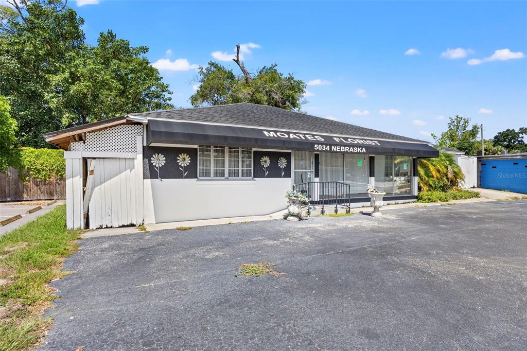 A single-story commercial building with a black awning and a paved parking lot — 5034 N NEBRASKA AVENUE, TAMPA, FL