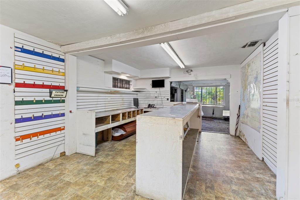 A commercial space features a service counter, slat wall panels, and a separate back room — 5034 N NEBRASKA AVENUE, TAMPA, FL