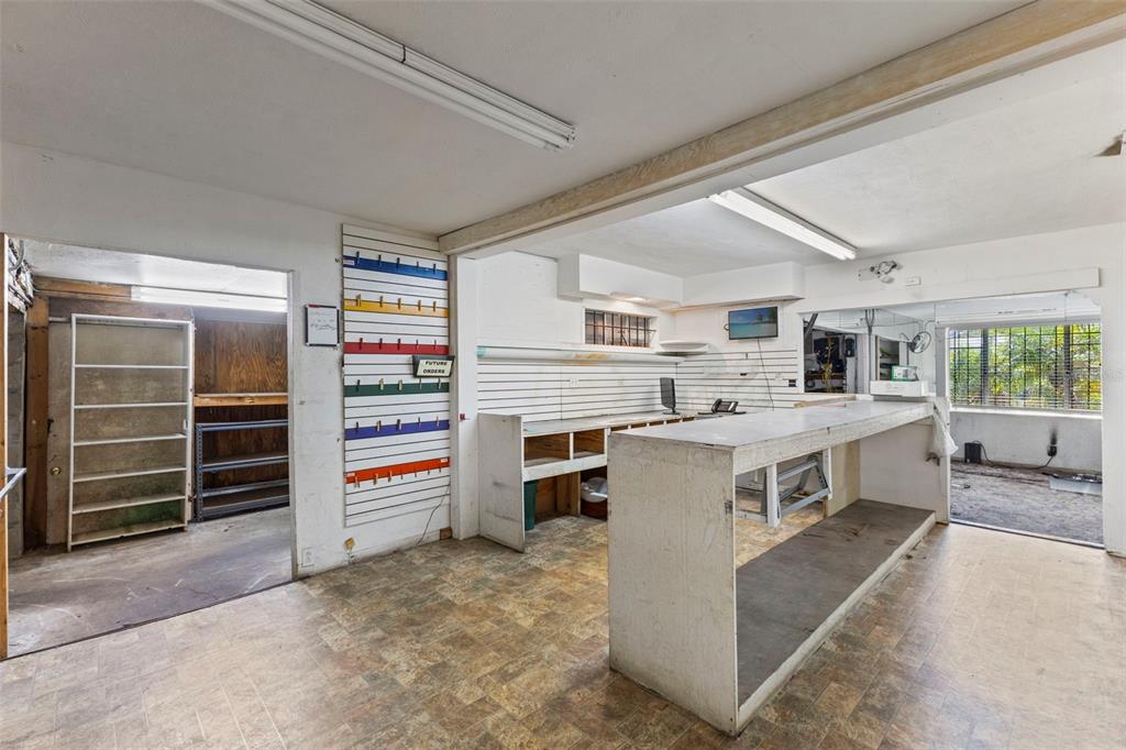 A commercial space featuring a service counter, slat wall panels, and a separate storage area — 5034 N NEBRASKA AVENUE, TAMPA, FL