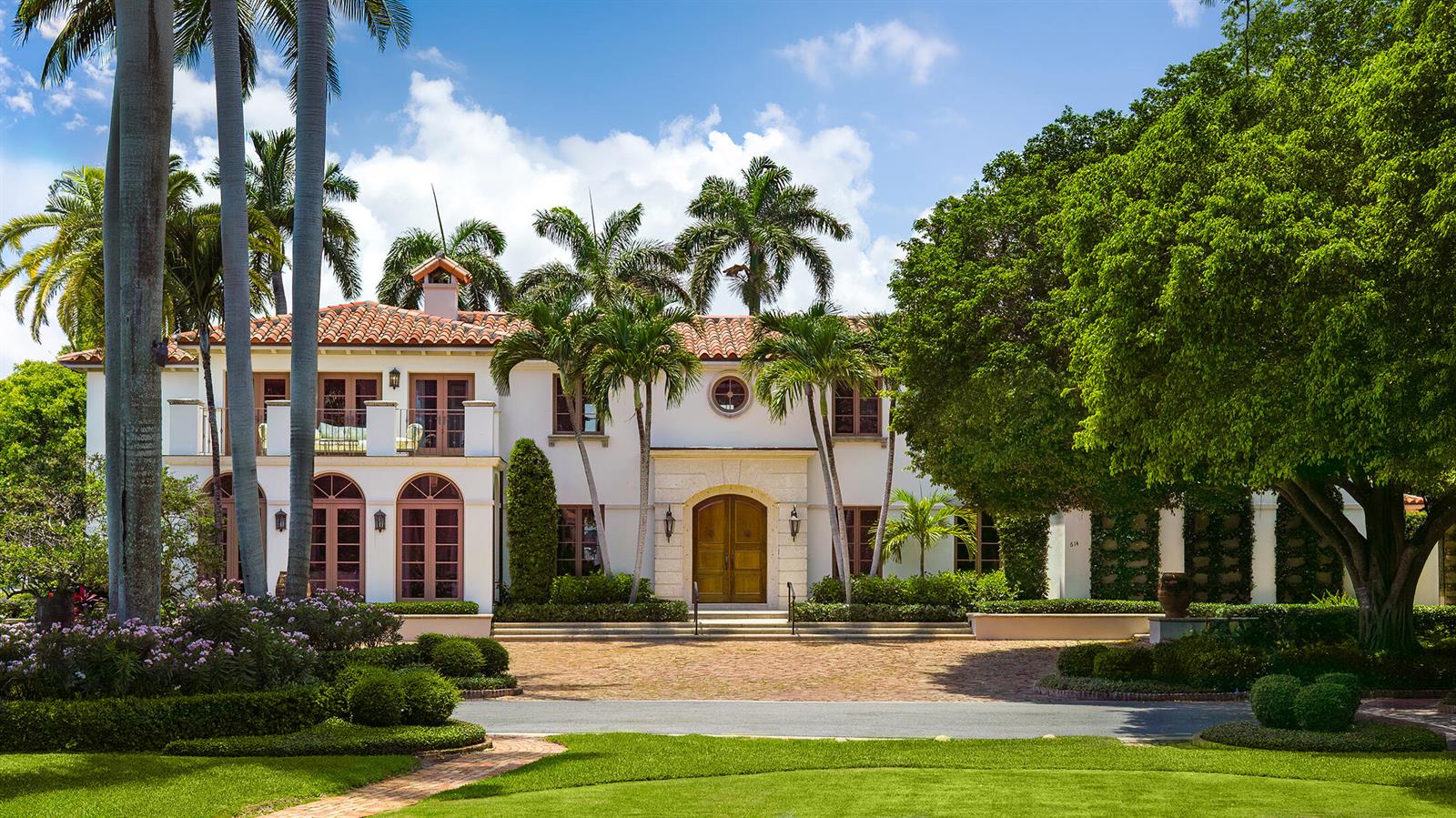 A two-story Mediterranean-style house with a tile roof, arched windows, and a paved circular driveway — 614 Tarpon Way, Palm Beach FL 33480, PALM BEACH, FL