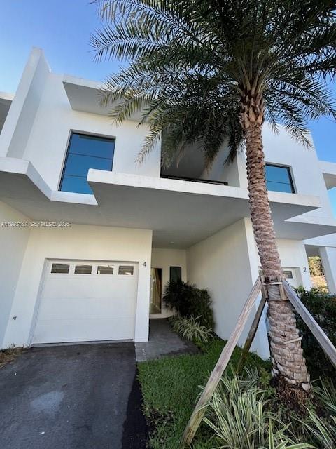 A modern white two-story townhouse features a garage, a balcony, and a tall palm tree — 2526 Pierce st # 10, Hollywood FL 33020, HOLLYWOOD, FL