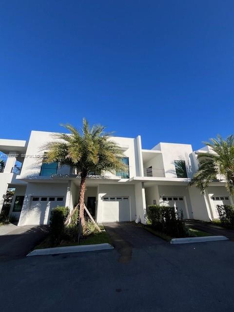 A row of modern white townhouses features attached garages and palm trees under a clear sky — 2526 Pierce st # 10, Hollywood FL 33020, HOLLYWOOD, FL