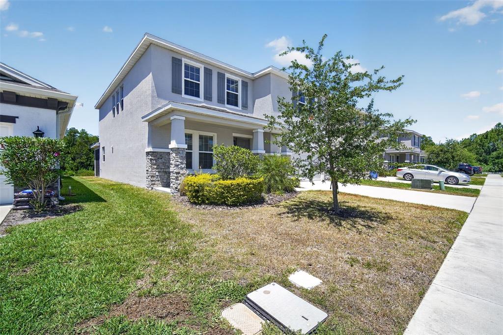 A two-story suburban house with a stone-accented porch and a front yard — 15394 SWEET SPRINGS BEND, ODESSA, FL