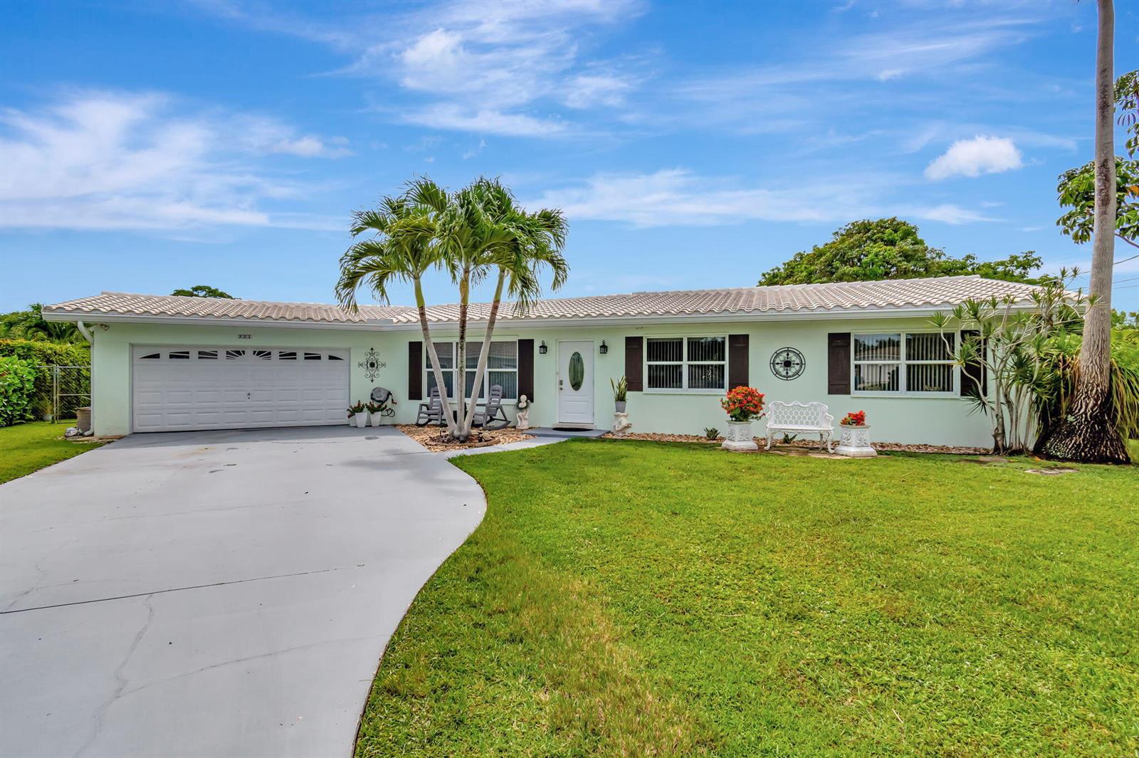 A light green single-story house with a white garage door and a concrete driveway — 302 Venice Drive, Boynton Beach FL 33426, BOYNTON BEACH, FL