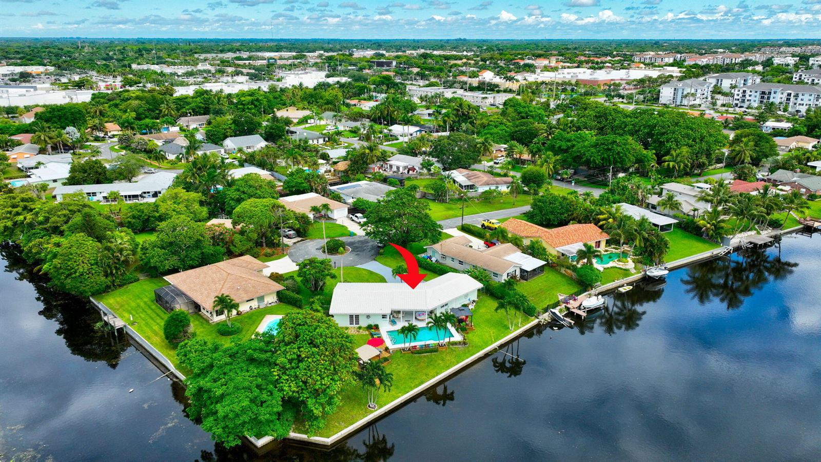An aerial view shows a waterfront house with a swimming pool and a red arrow — 302 Venice Drive, Boynton Beach FL 33426, BOYNTON BEACH, FL