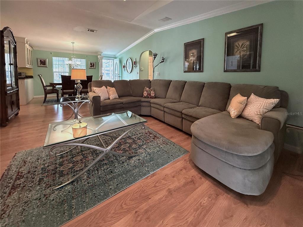 A living room features a large sectional sofa, a glass coffee table, and light wood flooring — 194 S PORT ROYAL LANE, APOLLO BEACH, FL