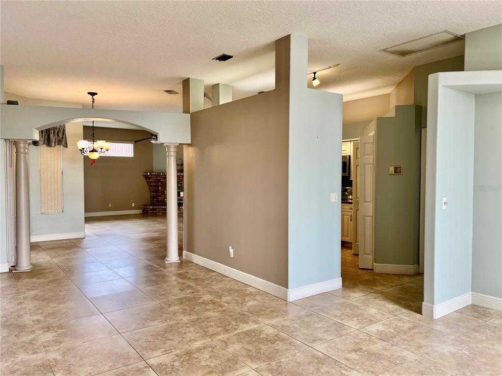 A living area with tile floors, an arched entryway, and a partial wall partition — 3715 72ND AVE E, SARASOTA, FL