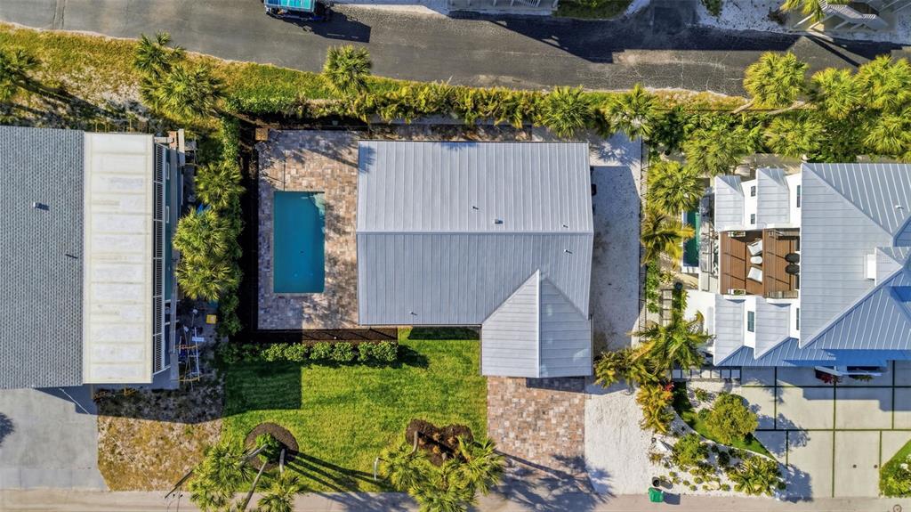 An aerial view shows a house with a metal roof, a swimming pool, and landscaping — 120 STANFORD DRIVE, ENGLEWOOD, FL