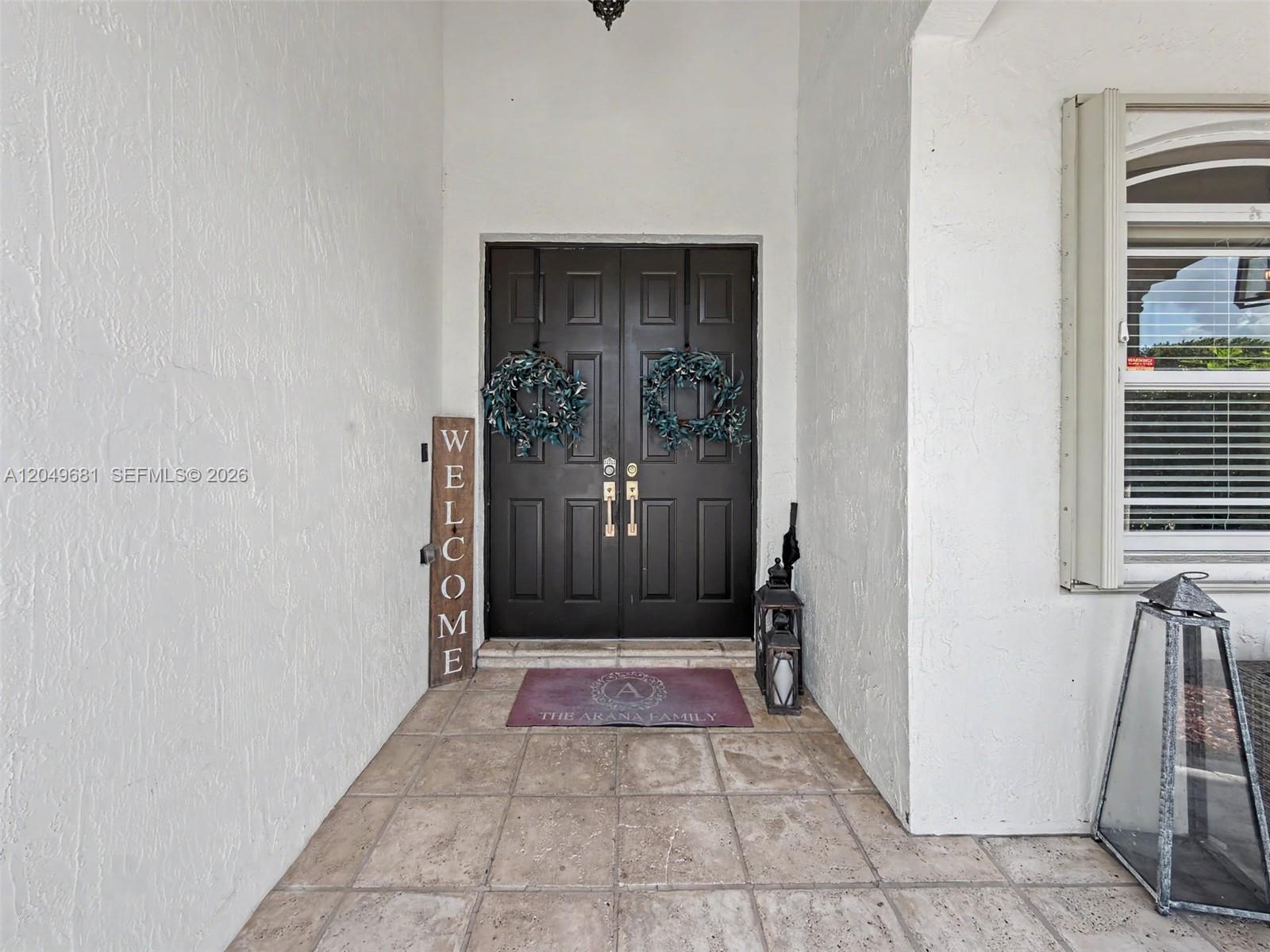 A front entryway features double dark doors, a welcome sign, and a personalized floor mat — 16519 SW 67th Ter, Miami FL 33193, MIAMI, FL