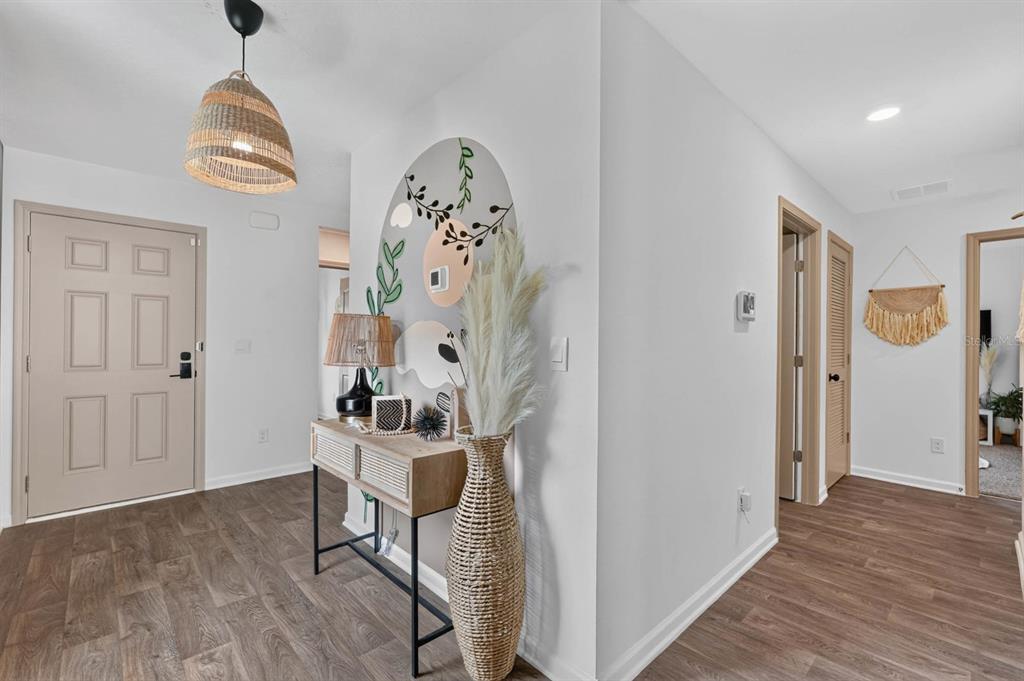 An entryway features a console table, a tall woven vase, and a decorative wall mural — 7 BILTMORE PLACE, PALM COAST, FL
