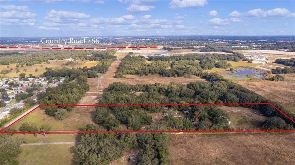 An aerial view shows a rectangular plot of land with trees and structures near roads — 38020 CHERRY LAKE ROAD, FRUITLAND PARK, FL