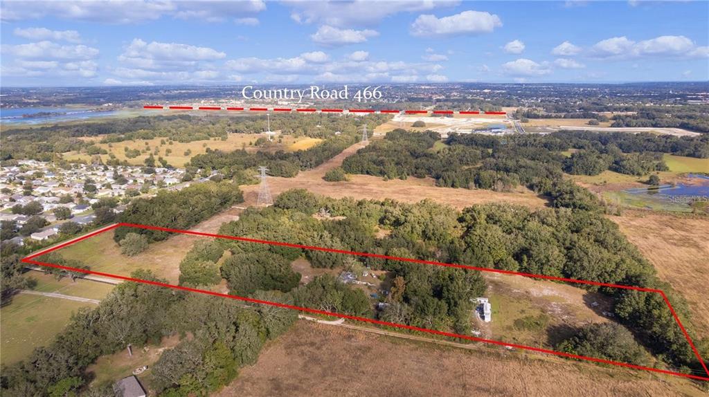 An aerial view shows a large, rectangular plot of land outlined in red near a road — 38020 CHERRY LAKE ROAD, FRUITLAND PARK, FL