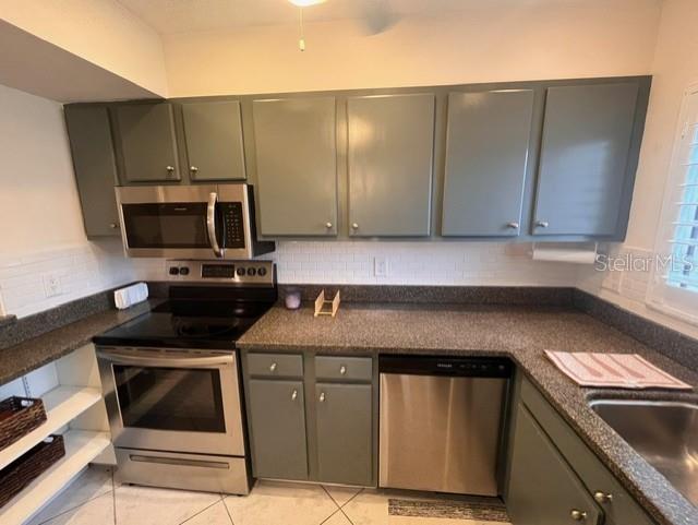 A kitchen features grey cabinets, stainless steel appliances, and dark countertops — 1614 STICKNEY POINT ROAD UNIT 102, SARASOTA, FL