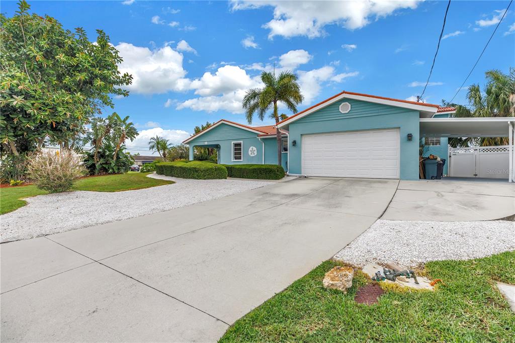 A light blue single-story house with a two-car garage and a paved driveway — 4911 PALMETTO POINT DRIVE, PALMETTO, FL
