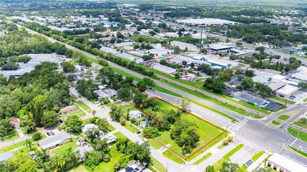 An aerial view shows a vacant, L-shaped lot outlined in red near a road intersection — 205 CHESTNUT STREET, OLDSMAR, FL