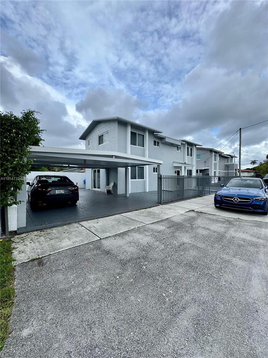 A two-story gray house features a covered carport and a blue car parked in front — 1671 SW 29th Ave, Miami FL 33145, MIAMI, FL