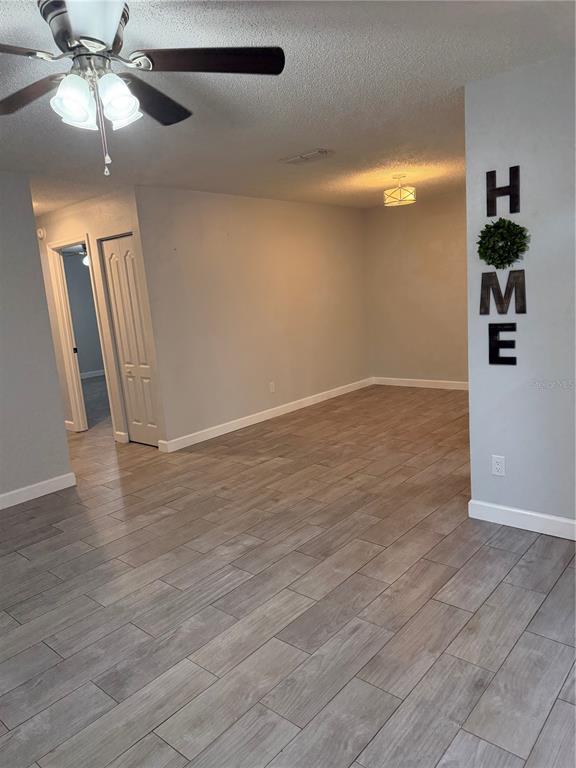 A room with light gray walls, wood-look tile flooring, a ceiling fan, and a wall sign — 2701 NE 10TH STREET UNIT 802, OCALA, FL