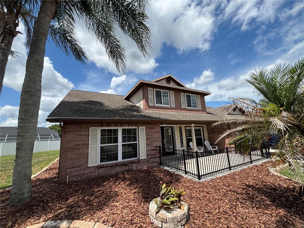 A brick house with a fenced front porch, palm trees, and a landscaped yard — 1435 BUCKNER ROAD, VALRICO, FL