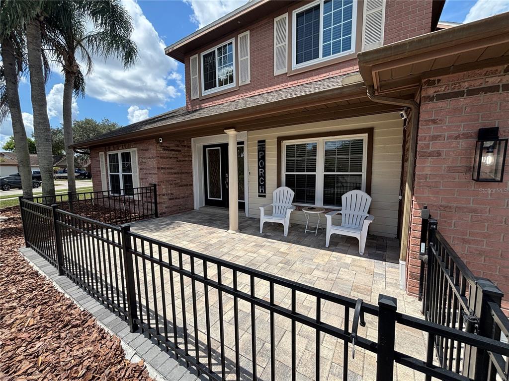 A brick house features a paved front porch enclosed by a black metal fence — 1435 BUCKNER ROAD, VALRICO, FL