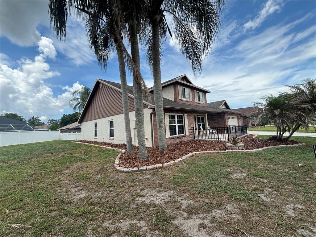 A two-story house with a brick and stucco exterior features palm trees and landscaping — 1435 BUCKNER ROAD, VALRICO, FL