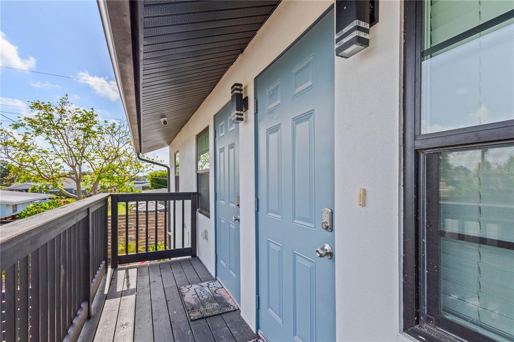 An exterior balcony features dark wooden railings and two light blue doors with keypad locks — 4219 60TH STREET COURT W, BRADENTON, FL